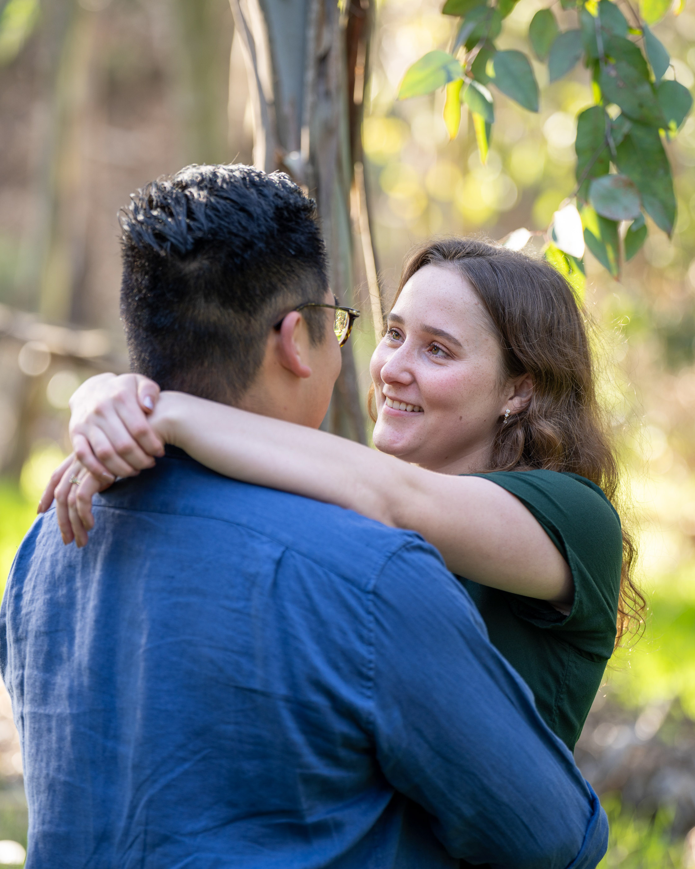 Couple embracing and smiling together during an outdoor engagement session