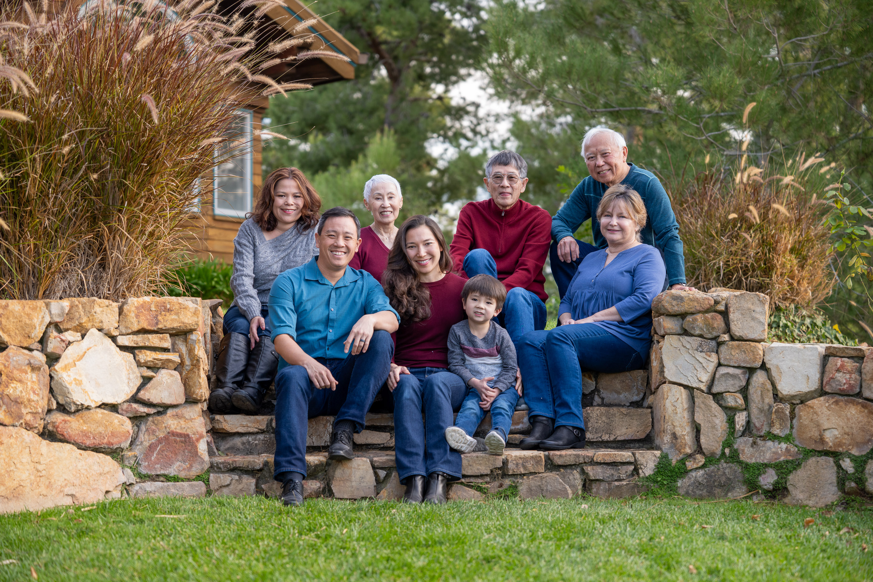 Large family portrait gathered together outdoors with grandparents, parents, and children