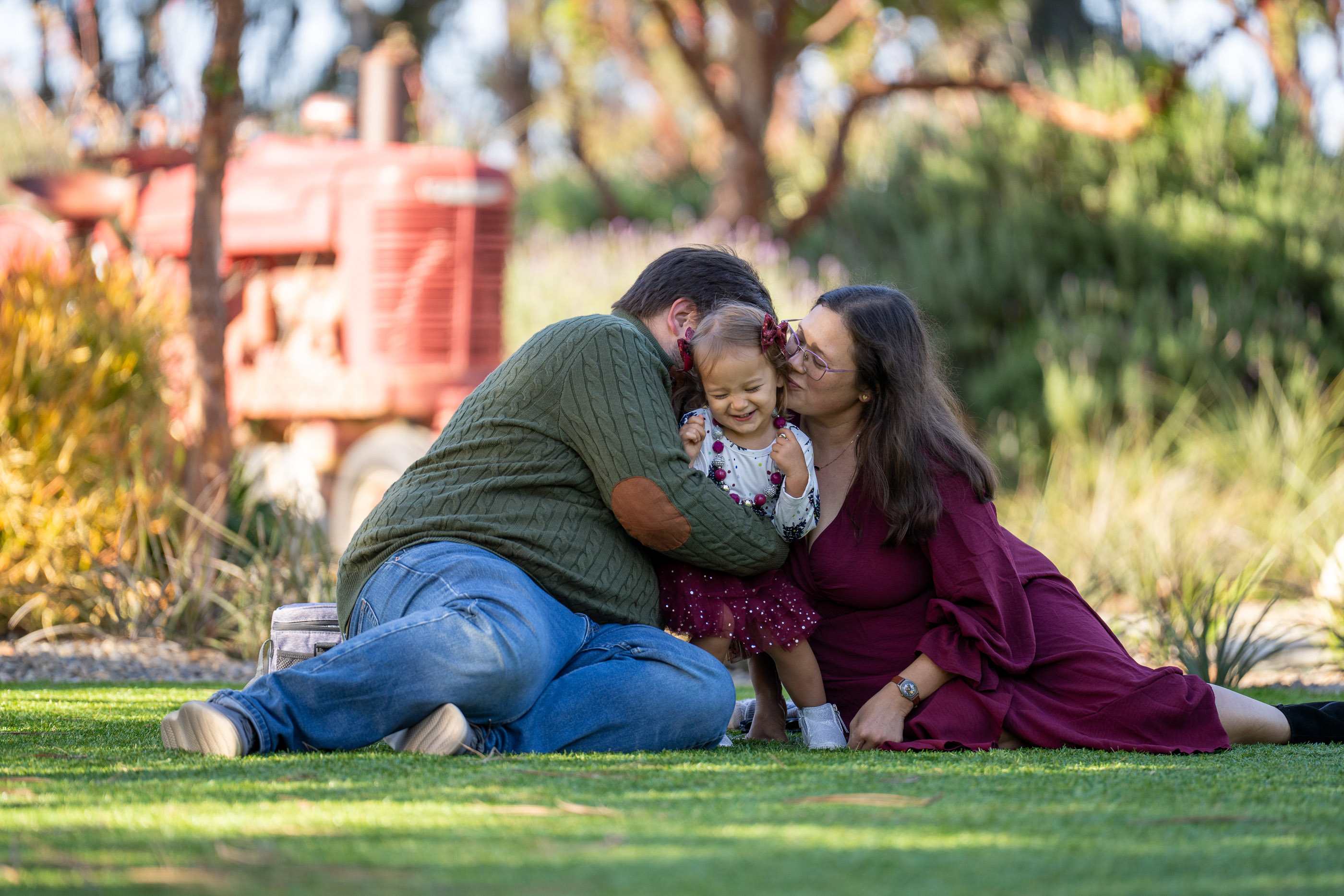 Family cuddling together on the grass during an outdoor family session
