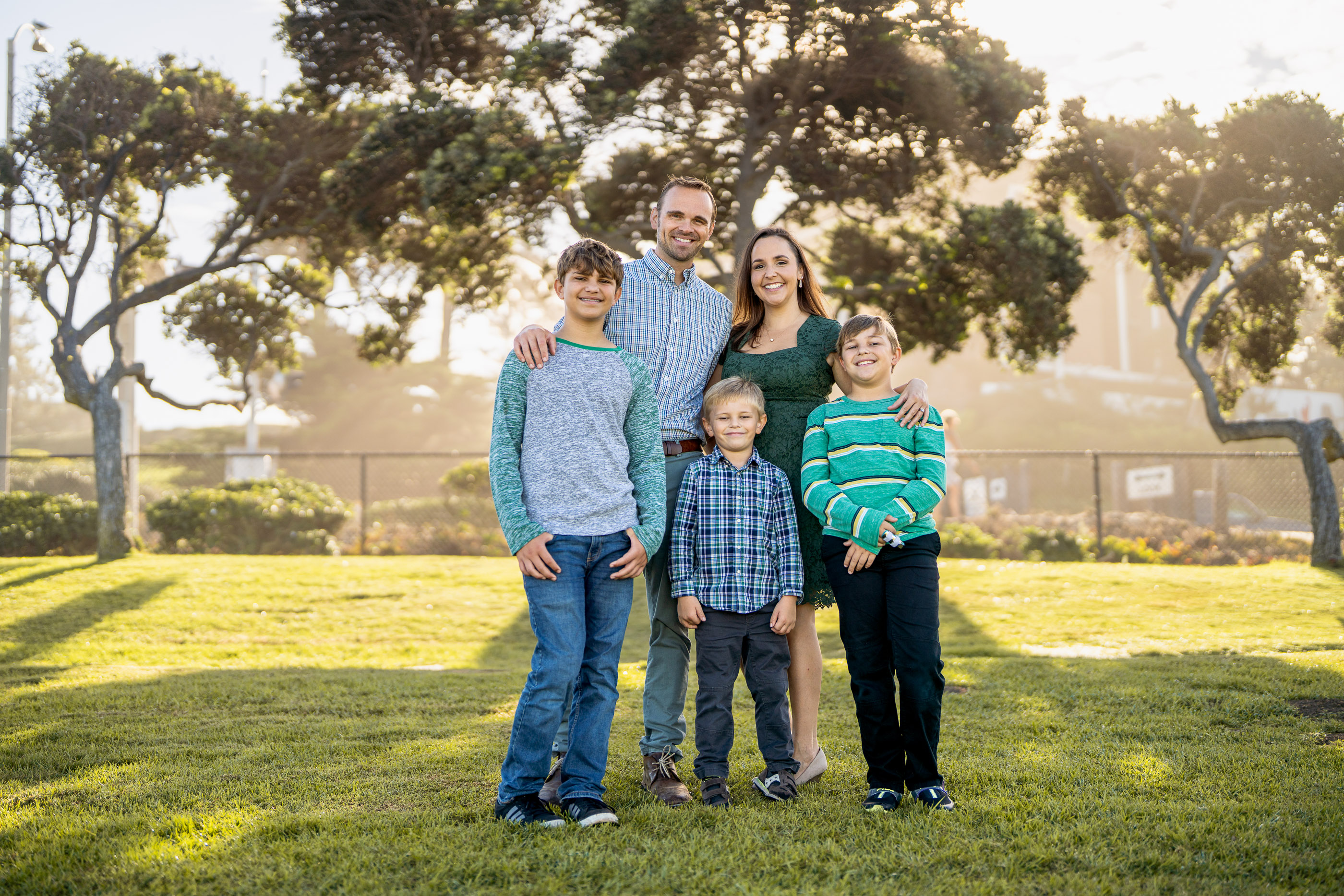 Family of parents and children standing together on a sunny lawn