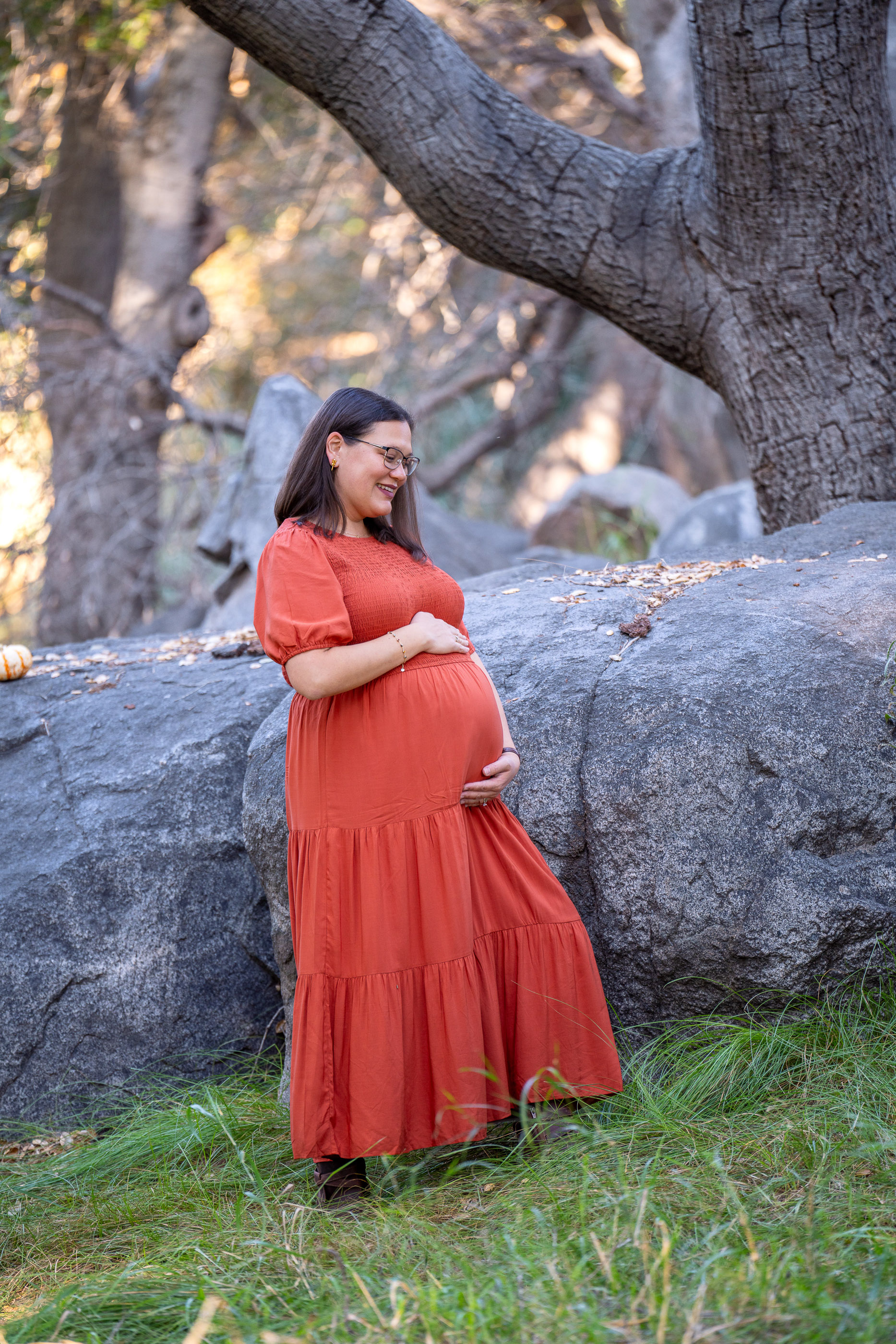 Pregnant couple standing together beneath a large tree during a maternity session